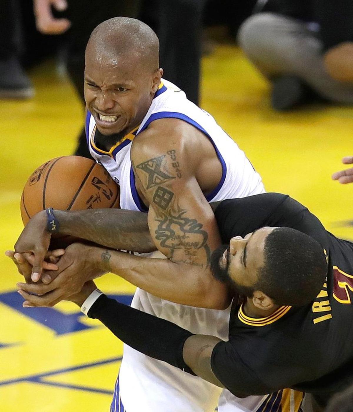 Golden State Warriors forward David West, left, wrestles for the ball with Cleveland Cavaliers guard Kyrie Irving during Game 5 of basketball's NBA Finals in Oakland, Calif., Monday, June 12, 2017.