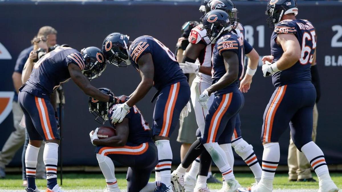 Chicago running back Tarik Cohen kneels as he celebrates his first NFL touchdown with his teammates during Bears’ game against the Atlanta Falcons on Sunday.
