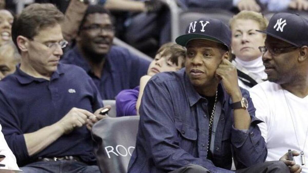 Rapper Jay-Z, bottom right, attends the Nets final NBA basketball home game April 23, 2012. He became minority owner of the NBA’s Nets franchise in 2005, eventually helping relocate the team from New Jersey to Brooklyn.