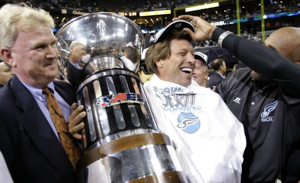 Jim Foster, left, founder of the Arena Football League, holds the trophy with Jon Bon Jovi, a majority owner of the Philadelphia Soul, after the Soul won the ArenaBowl XXII football game in 2008. Bon Jovi owned the team from 2004 to 2009.