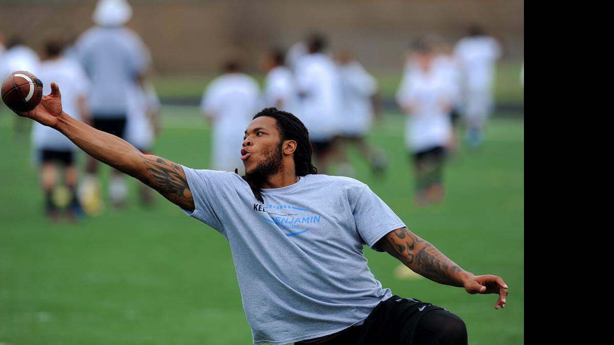 
Carolina Panthers wide receiver Kelvin Benjamin reaches out to catch a ball during his football camp at Rocky River High School in Mint Hill on Friday. Benjamin, who was dogged by hamstring injuries during OTAs, expects to be full go for training camp. 
