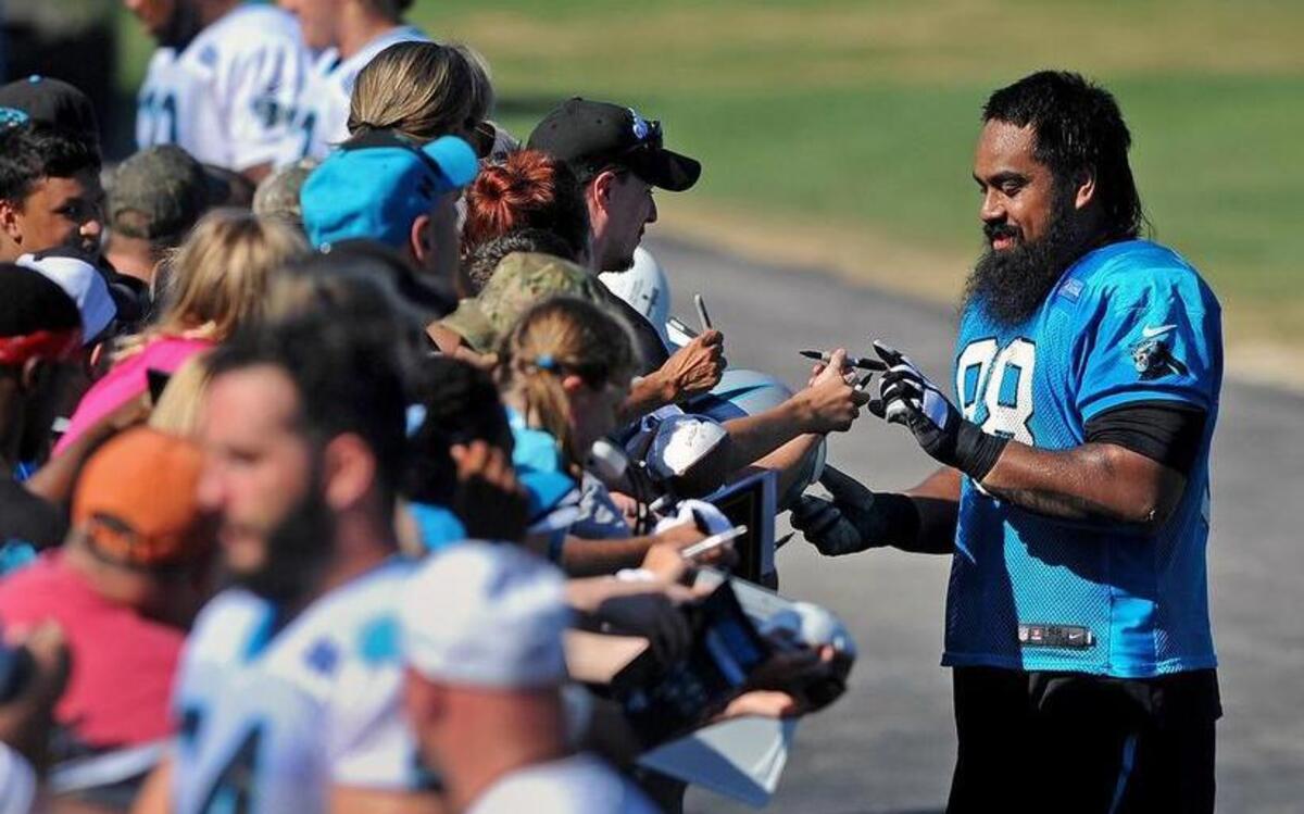 
Carolina Panthers defensive tackle Star Lotulelei, right, stops to sign autographs for fans following practice at Wofford College in Spartanburg, S.C., on Saturday, Aug. 1, 2015. 
