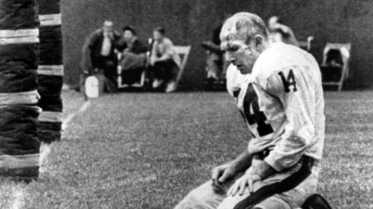 In this 1964 photo, New York Giants quarterback Y.A. Tittle kneels after being sacked by John Baker of the Pittsburgh Steelers. Tittle, the Hall of Fame quarterback and 1963 NFL Most Valuable Player, has died. He was 90.