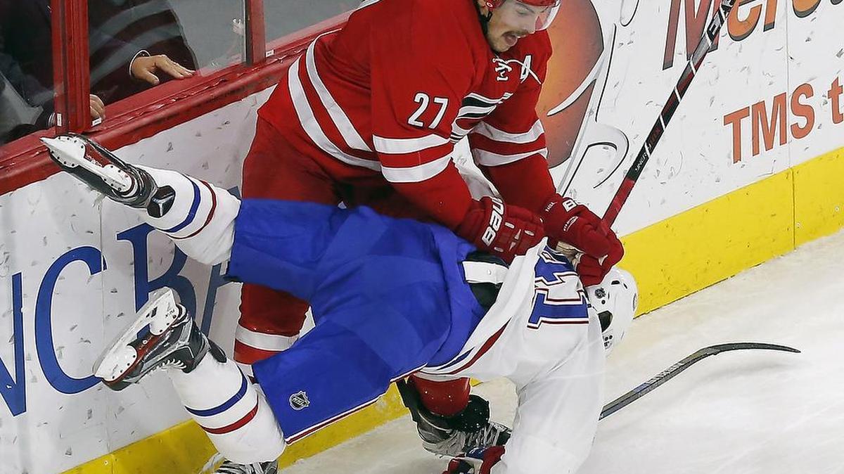 The Canes Justin Faulk (27) slams the Montreal Canadiens' Paul Byron (41)to the ice during the third period.