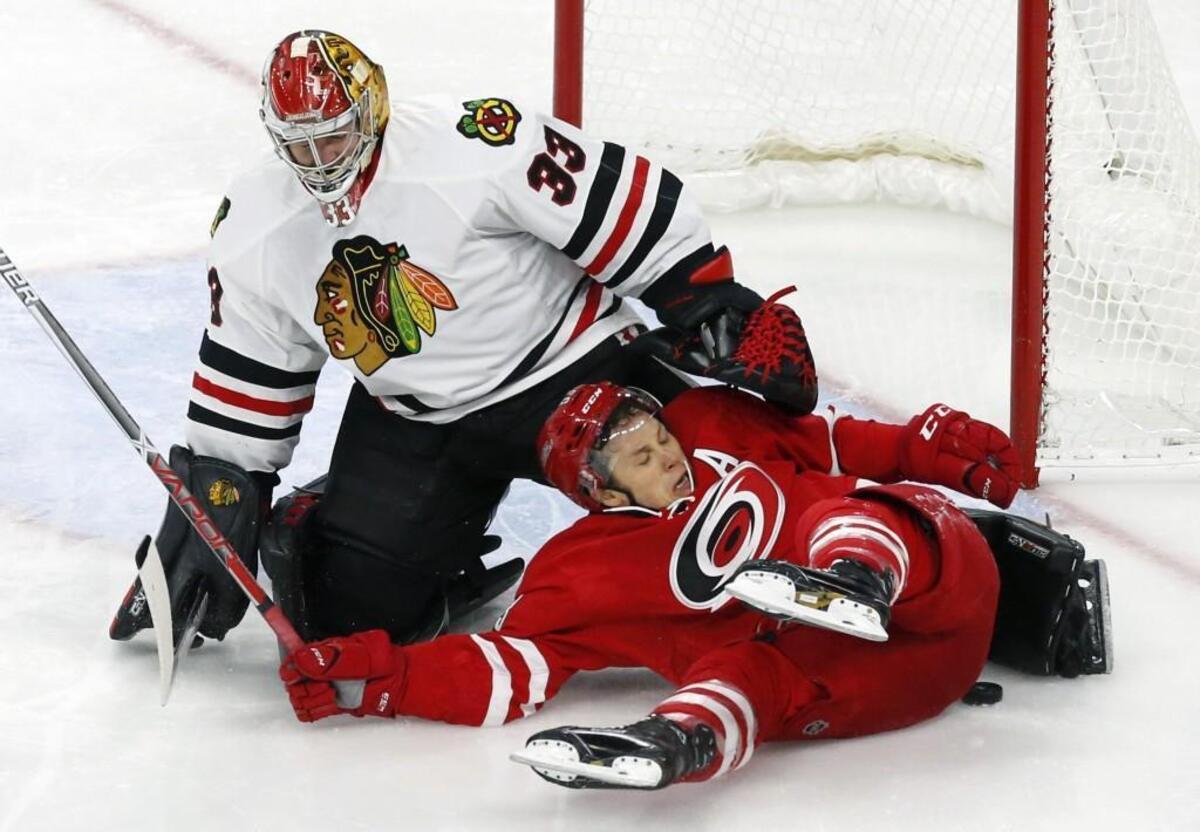 The Canes' Jeff Skinner (53) crashes into Scott Darling (33) as he drives the net during game played between the Carolina Hurricanes and the Chicago Blackhawks at PNC Arena on Dec. 30, 2016. The Canes beat the Blackhawks 3-2.