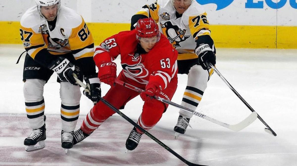 Hurricanes’ Jeff Skinner battles against the Penguins’ Sidney Crosby, left, and Patric Hornqvist, right, for the puck in February. The Canes announced their upcoming exhibition schedule on Thursday.