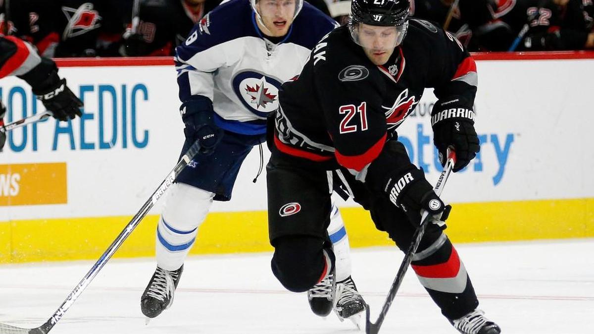 The Canes’ Lee Stempniak (21) moves the puck against the Winnipeg Jets' Andrew Copp (9) at PNC Arena on Nov. 20, 2016.