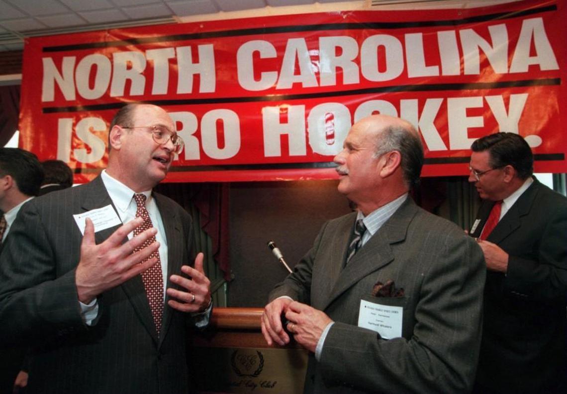 Harvey Scmitt with the Raleigh Chamber of Commerce, left, talks with Hartford Whalers owner Peter Karmanos after a press conference on May 6, 1997 when Karmanos said he was moving his hockey team to Raleigh and renaming it the Carolina Hurricanes.