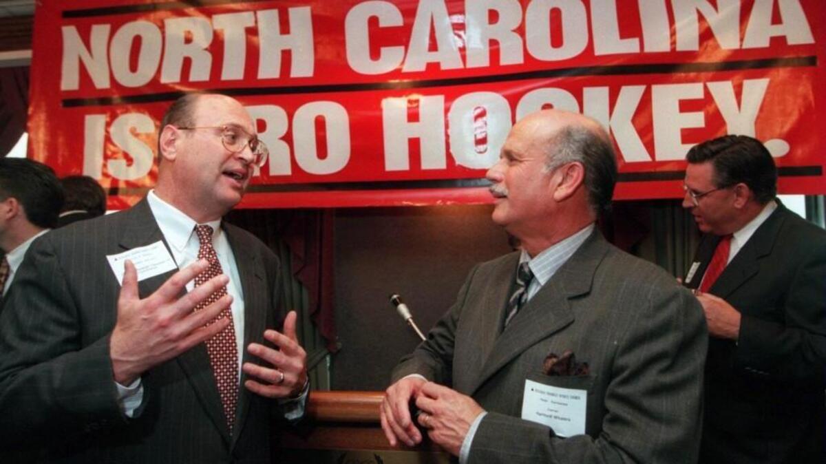 Harvey Schmitt, then with the Raleigh Chamber of Commerce, left, talks with Carolina Hurricanes owner Peter Karmanos after a press conference on May 6, 1997 when Karmanos said he was moving his hockey team to Raleigh from Hartford, Conn.