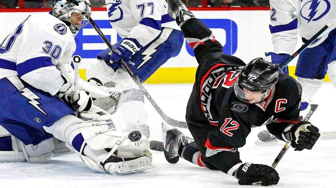 
The Canes Eric Staal (12) battles the Tampa Bay Lightning's Ben Bishop (30), Victor Hedman (77) and Andrej Sustr (62) during the first period of an NHL game played between the Carolina Hurricanes and the Tampa Bay Lightning at PNC Arena in Raleigh, N.C. on Jan. 27, 2015.
