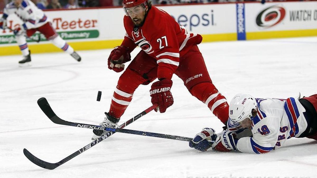 The Canes' Justin Faulk (27) works against the New York Rangers' Jesper Fast (19) during the second period.