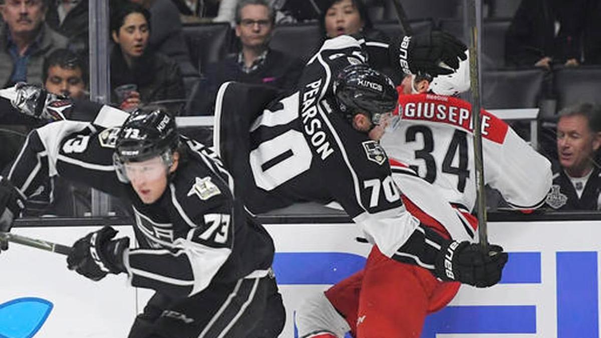Los Angeles Kings left wing Tanner Pearson, center, collides with Carolina Hurricanes left wing Phillip Di Giuseppe, right, as center Tyler Toffoli skates by during the second period of an NHL hockey game, Thursday, Dec. 8, 2016, in Los Angeles.