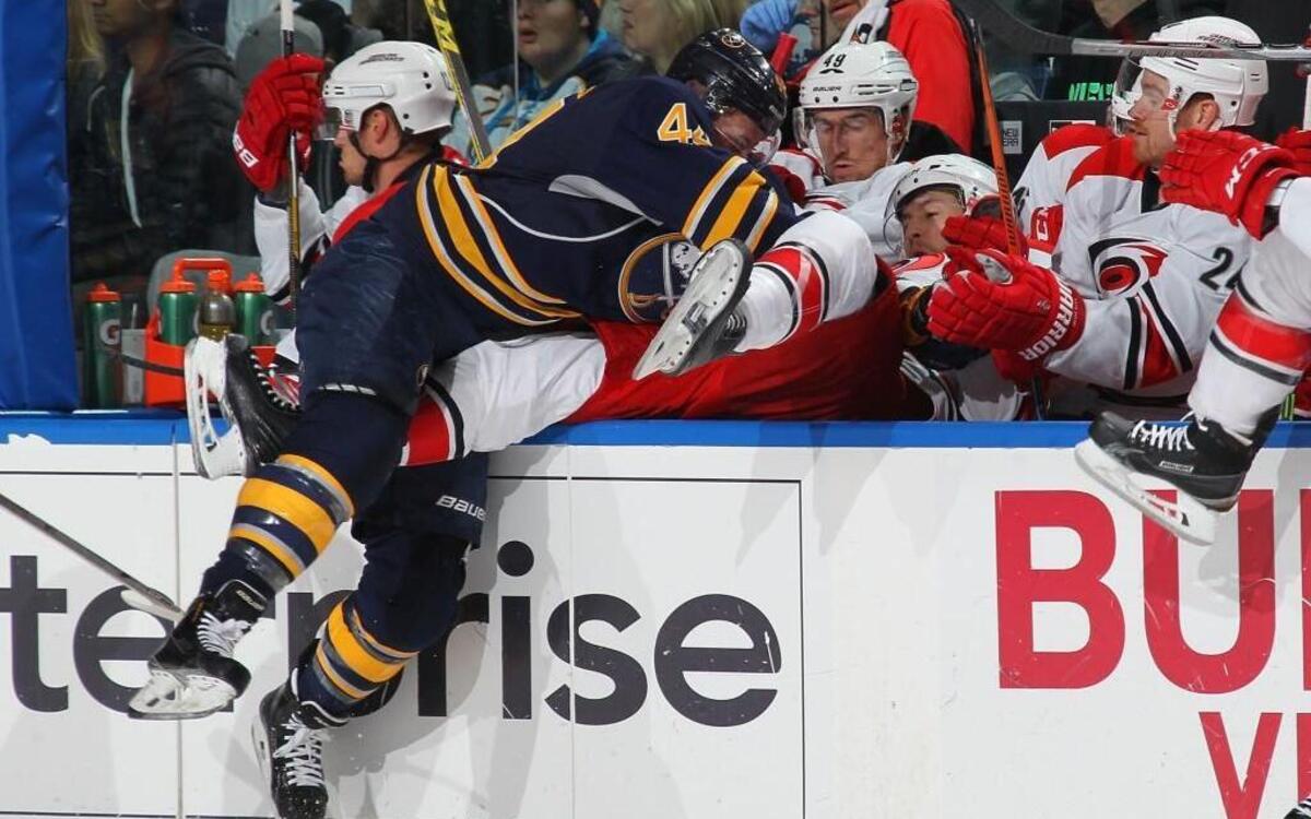 Buffalo Sabre Nicolas Deslauriers (44) checks Hurricane Victor Rask into the bench during the game at the First Niagara Center in Buffalo,.