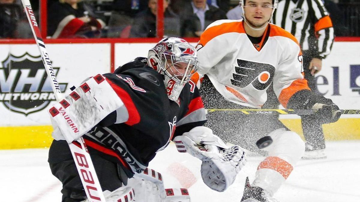 The Carolina Hurricanes' Cam Ward (30) blocks a shot as the Philadelphia Scott Laughton (21) looks on during the second period at PNC Arena in Raleigh.
