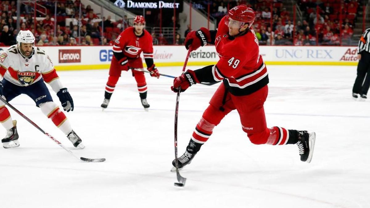 The Canes' Victor Rask (49) shoots against the Florida Panthers' Derek MacKenzie (17) at the PNC Arena in Raleigh on Dec. 2, 2017.