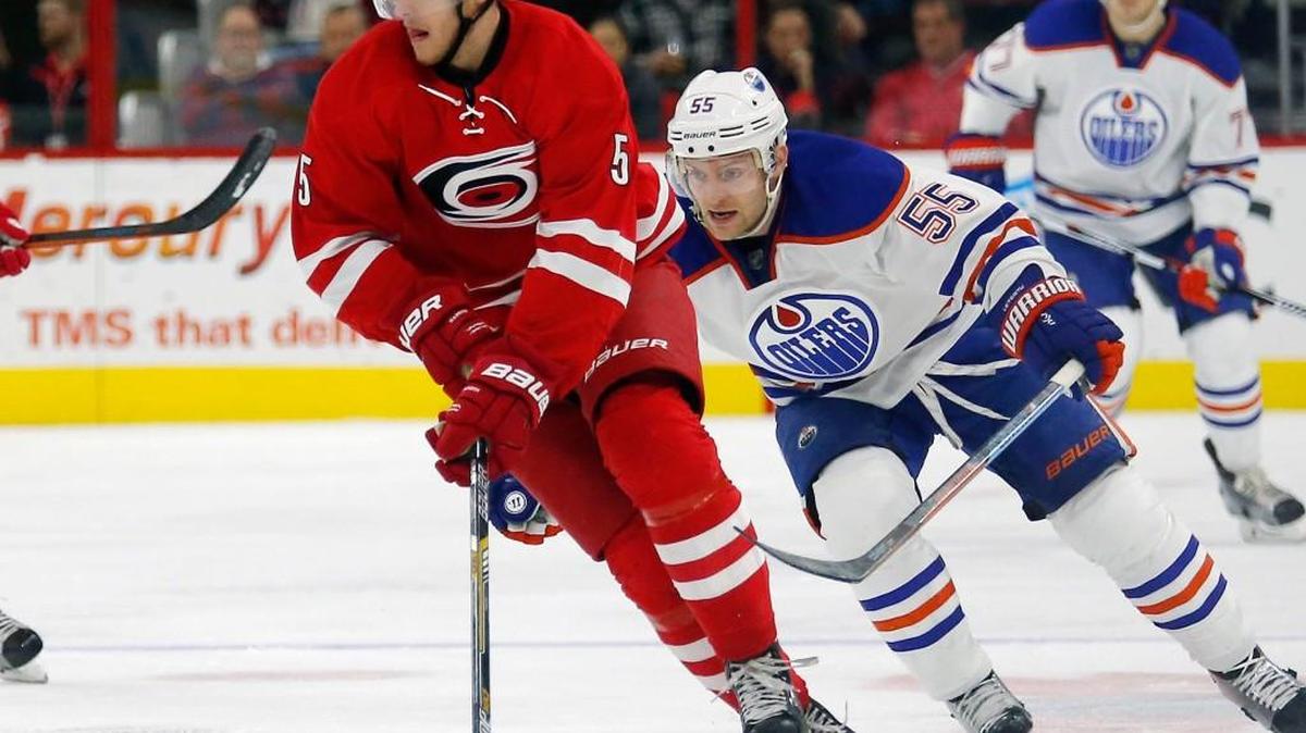The Canes Noah Hanifin (5) works against the Edmonton Oilers' Mark Letestu (55) during an NHL game played between the Carolina Hurricanes and the Edmonton Oilers at PNC Arena in November. The Canes beat the Oilers 4-1.