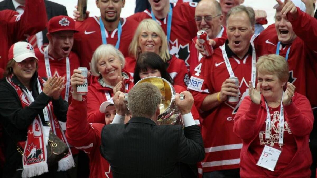 Canada’s head coach Bill Peters drinks champagne from the trophy as team cheer on ice after winning the Ice Hockey World Championships final match between Finland and Canada, in Moscow, Russia, on Sunday, May 22, 2016.