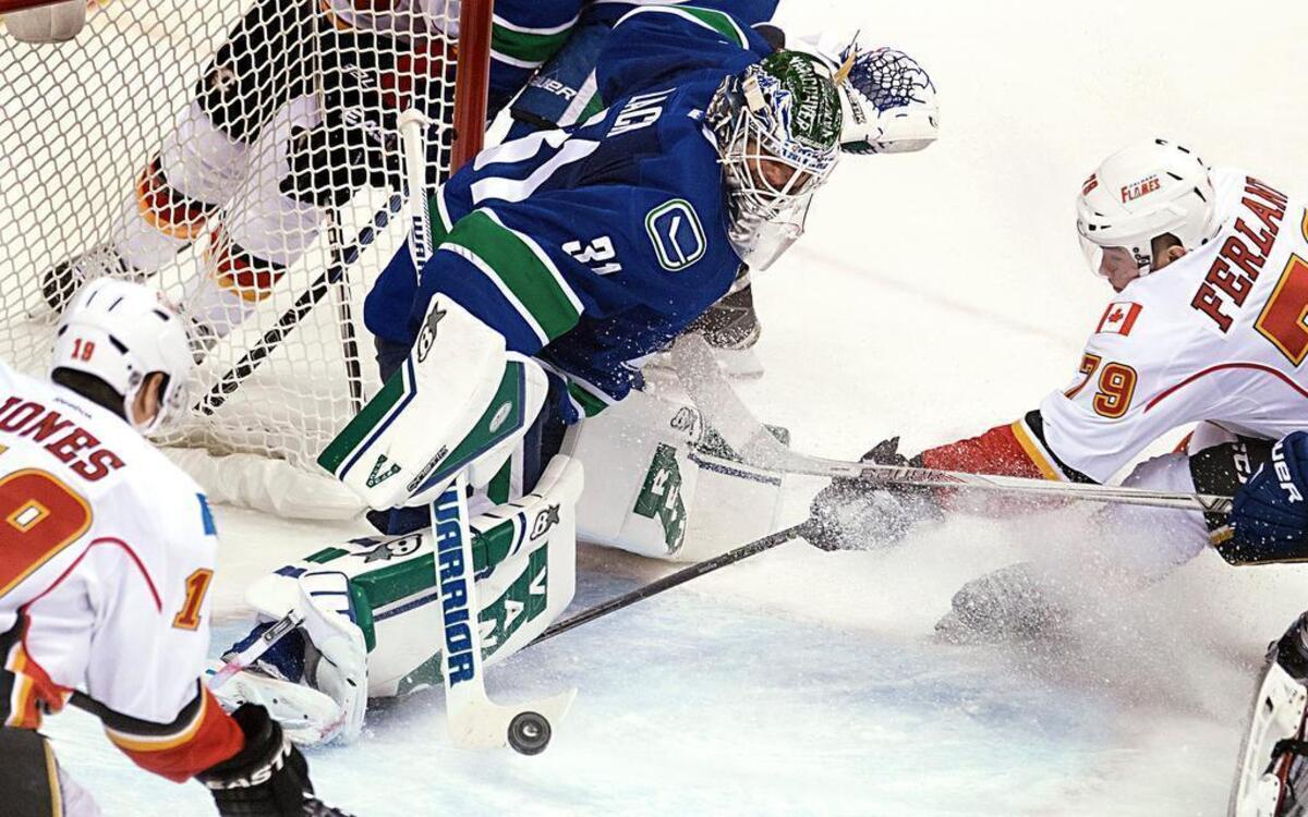 
Vancouver Canucks goalie Eddie Lack (31), of Sweden, stops Calgary Flames' Michael Ferland during the second period of Game 2 of an NHL hockey first-round playoff series, Friday, April 17, 2015, in Vancouver, British Columbia. 
