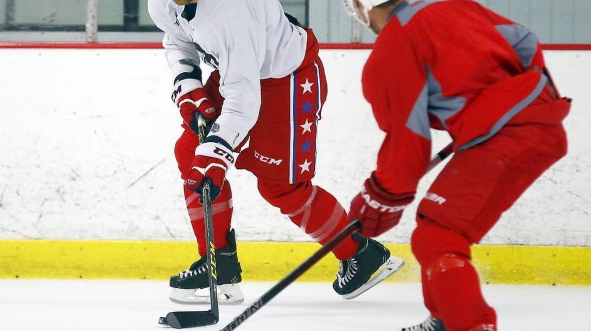 
Former Carolina Hurricane Tim Gleason, left, moves the puck near the Canes' John-Michael Liles.
