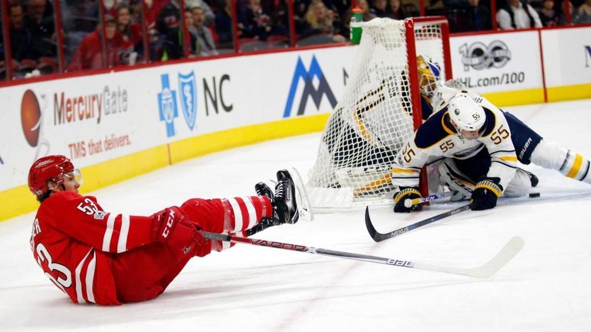 The Canes' Jeff Skinner (53) tumbles past the Buffalo Sabres' Anders Nilsson (31) and Justin Bailey (56) at PNC Arena on Jan. 13, 2017. Bailey was called for a penalty on the play.