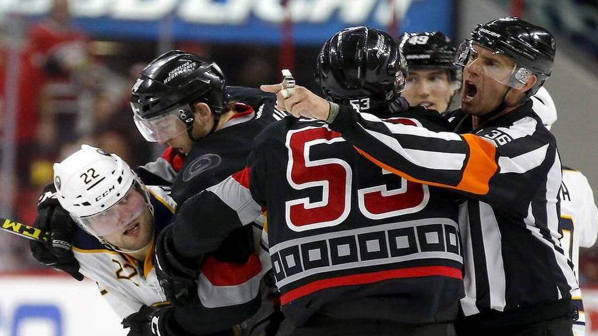 The Carolina Hurricanes' Jaccob Slavin (74) and Jeff Skinner (53) mix it up with the Buffalo Sabres' Johan Larsson (22) during the second period. Several players from both teams were penalized on the play.


