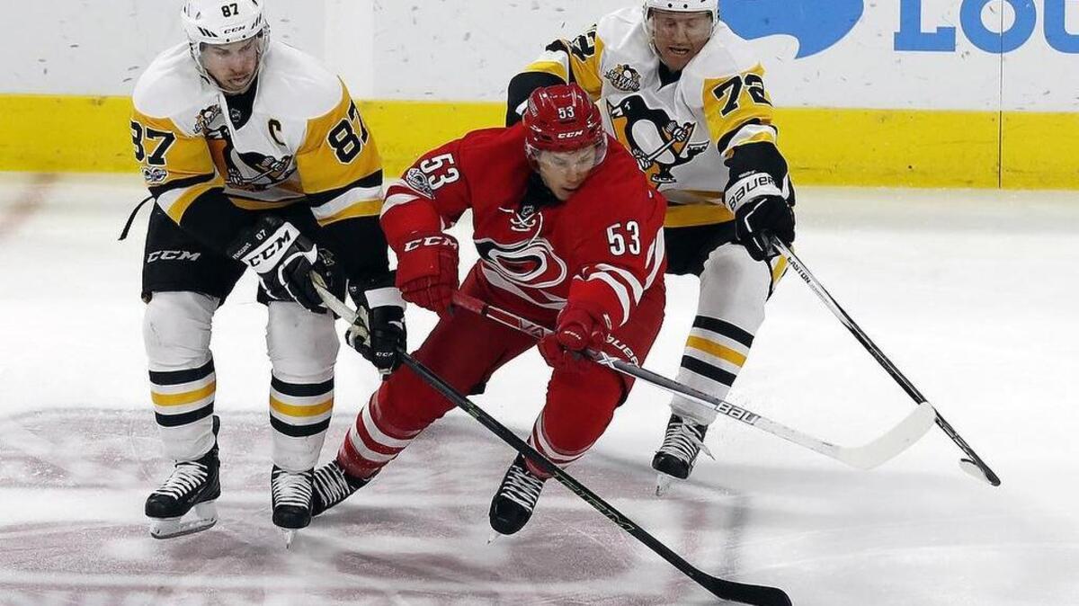 The Pittsburgh Penguins' Sidney Crosby (87) and Patric Hornqvist (72) battle the Canes' Jeff Skinner (53) for the puck during the third period.