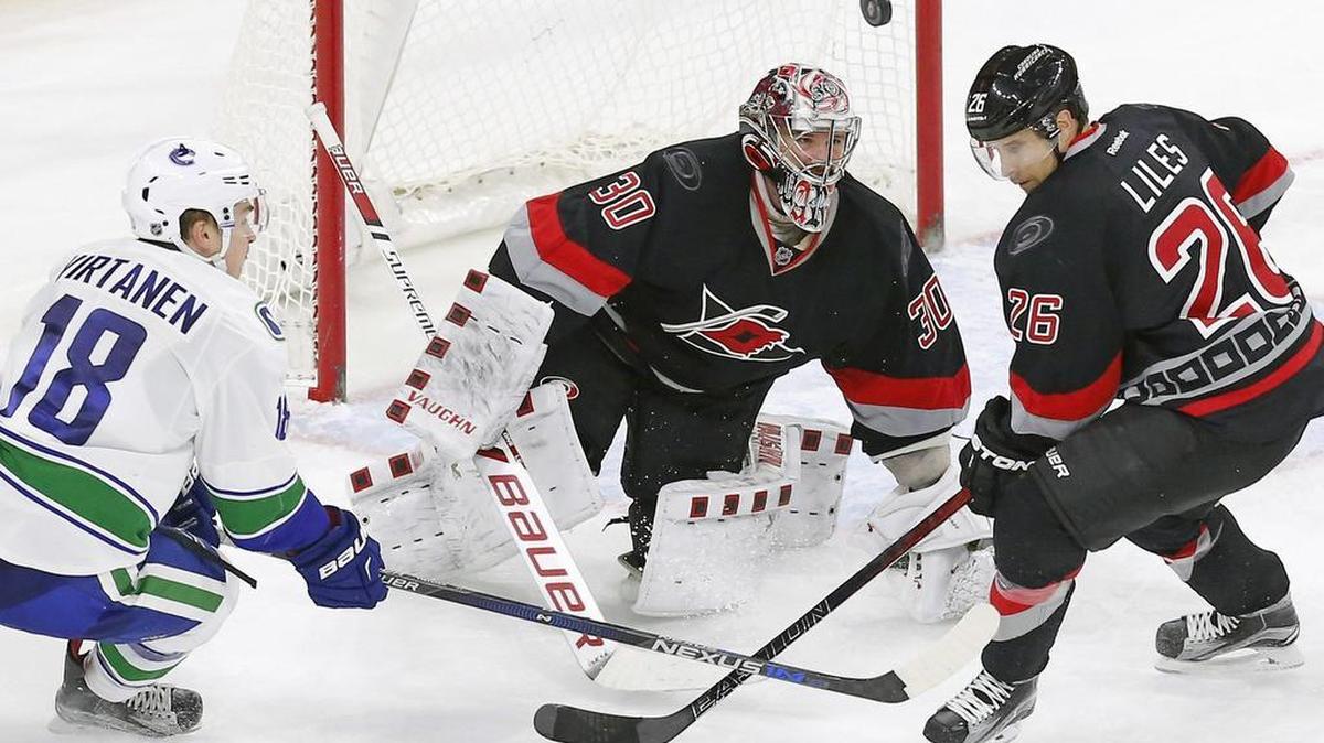 The Carolina Hurricanes' Cam Ward (30) and John-Michael Liles (26) defend the Vancouver Canucks' Jake Virtanen (18) during the third period of an NHL game played between the Carolina Hurricanes and the Vancouver Canucks at the PNC Arena on Jan. 15. The Canucks beat the Canes 3-2 in overtime.