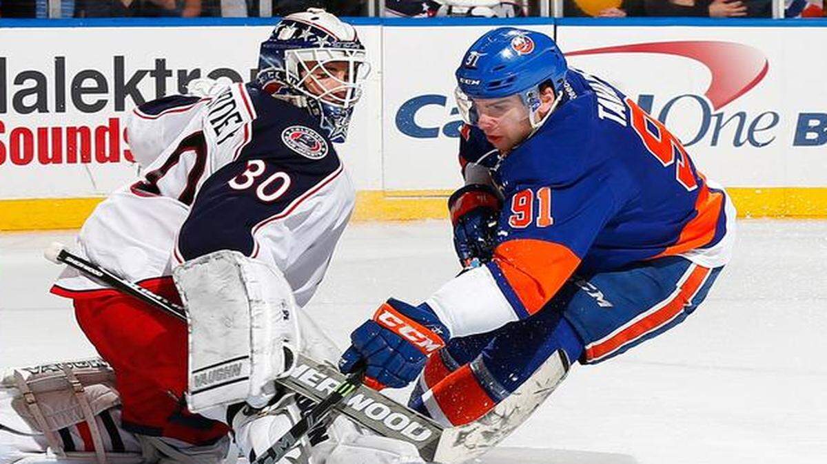 
John Tavares #91 of the New York Islanders scores a shootout goal against Curtis McElhinney #30 of the Columbus Blue Jackets at Nassau Veterans Memorial Coliseum on April 11, 2015 in Uniondale, New York. 
