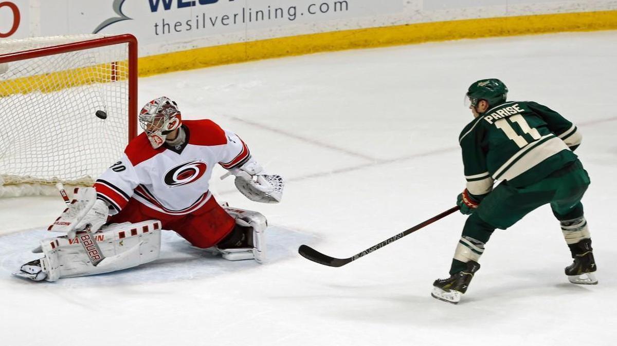 Minnesota Wild's Zach Parise, right, scores the winning shootout goal against Carolina Hurricanes goalie Cam Ward in St. Paul, Minn.