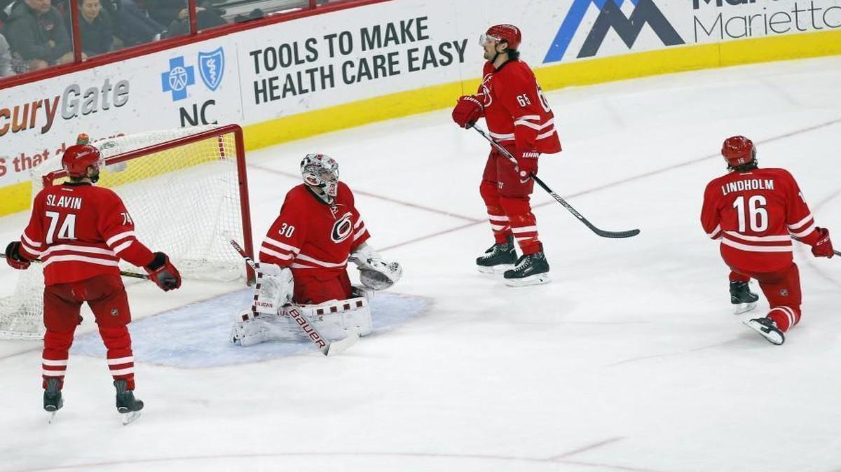 The Carolina Hurricanes' Jaccob Slavin (74), goalie Cam Ward, Ron Hainsey (65) and Elias Lindholm (16) react after the Tampa Bay Lightning's Steven Stamkos fired what proved to be the game-winning shot during the third period at PNC Arena in Raleigh.