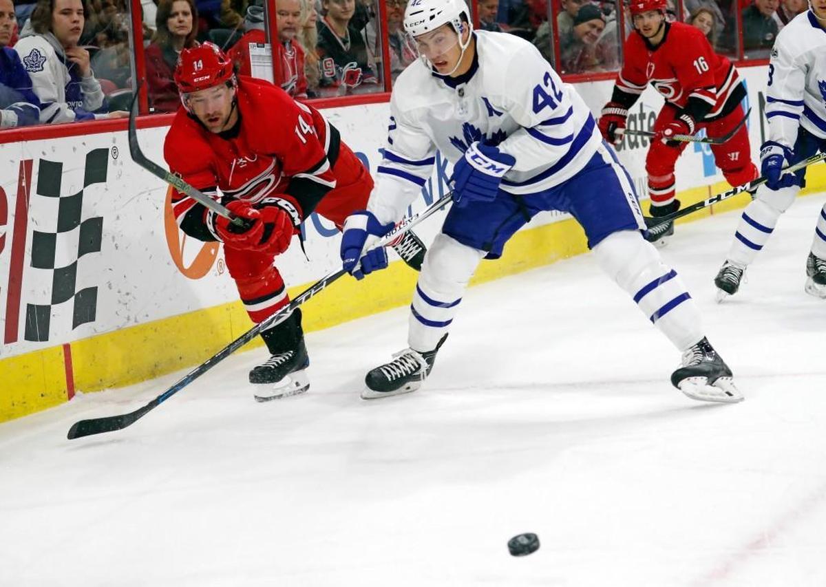 The Canes' Justin Williams (14) and the Leafs' Tyler Bozak (42) go for the puck during the first period.