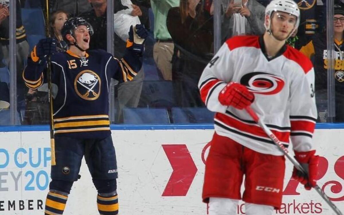 Buffalo Sabre Jack Eichel celebrates after scoring the winning goal with one second remaining in overtime as Carolina Hurricane Phillip DiGiuseppe skates away during the game at the First Niagara Center in Buffalo, NY.