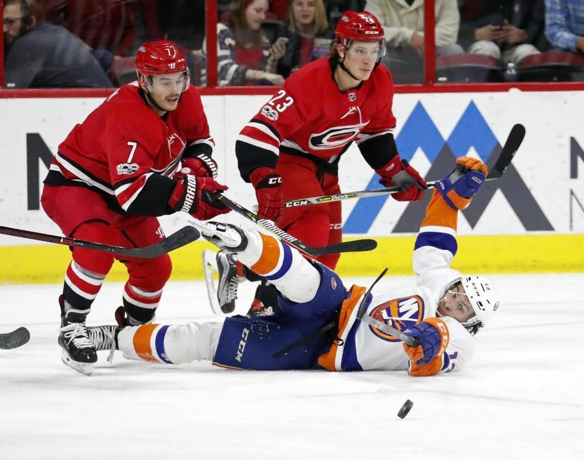 The Canes' Derek Ryan (7) and Brock McGinn (23) fight the Islanders' Mathew Barzal (13) for the puck during the second period at PNC Arena on Nov. 19, 2017.