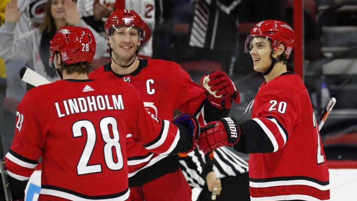 The Canes' Sebastian Aho (20) celebrates his goal with Elias Lindholm (28) and Jordan Staal (11) during the first period of an NHL game played between the Carolina Hurricanes and the New York Islanders at PNC Arena in Raleigh, N.C. on Nov. 19, 2017.