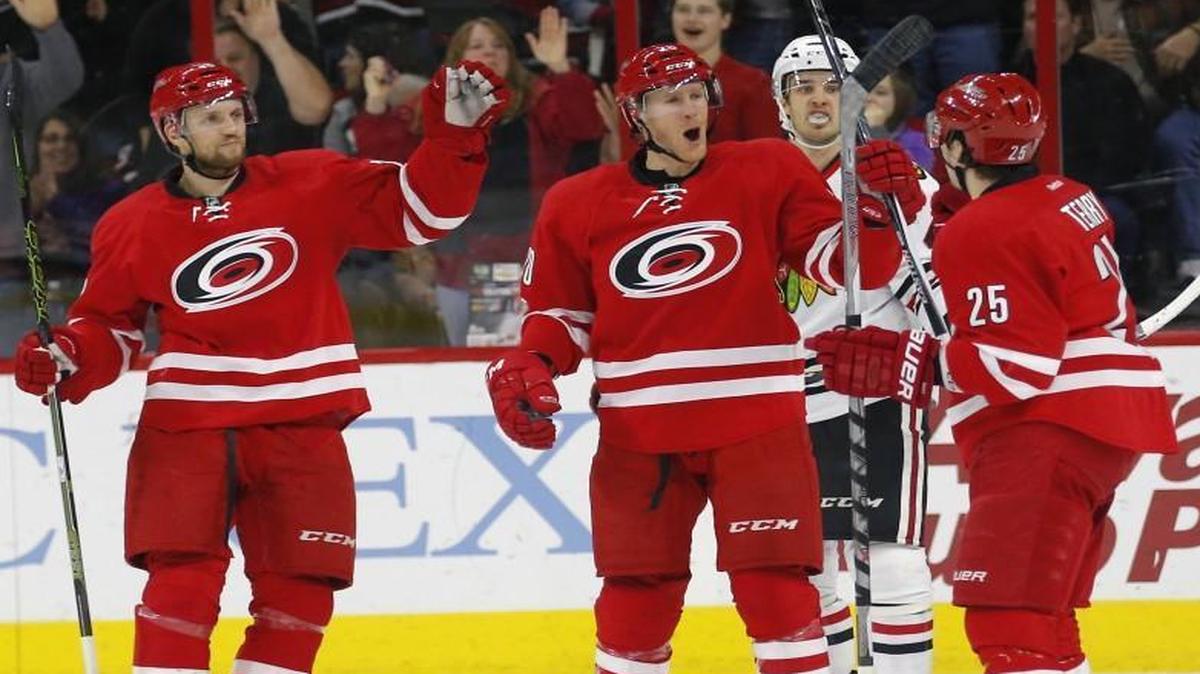 The Carolina Hurricanes' Riley Nash (20) celebrates his goal with Jay McClement (18) and Chris Terry (25) while the Chicago Blackhawks' Corey Crawford (50) skates away during the first period at PNC Arena in Raleigh.