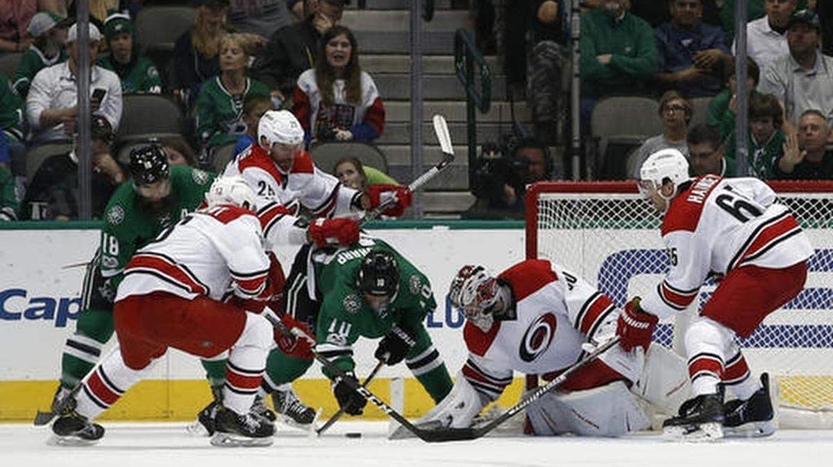 Dallas Stars' Patrick Sharp (10) and Carolina Hurricanes goalie Cam Ward battle for the puck as Patrick Eaves (18), Jay McClement (18), Viktor Stalberg (25) and Ron Hainsey (65) skate in during the second period of an NHL hockey game, Saturday, Feb. 11, 2017, in Dallas.