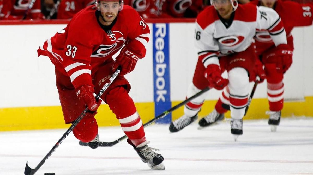 The Canes Red team’s Derek Ryan (33) handles the puck while the White team’s Jake Chelios pursues as the Carolina Hurricanes hold red-white scrimmage game at PNC Arena in Raleigh on Sept. 25, 2016. The Canes Carnival, with games, music and food outside and the players had autograph sessions inside, was held before the game. The White team beat the Red team, 3-2.