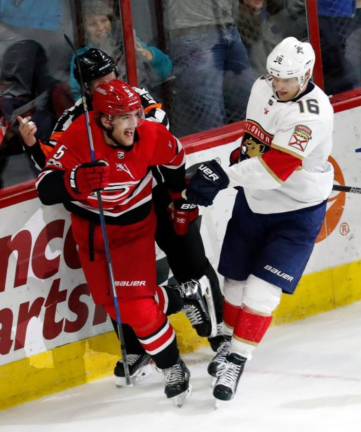The Canes' Noah Hanifin (5) celebrates his game winning goal in front of the Panthers' Aleksander Barkov (16) during the overtime period at PNC Arena on Dec. 2, 2017. The Canes beat the Panthers 3-2 in overtime.