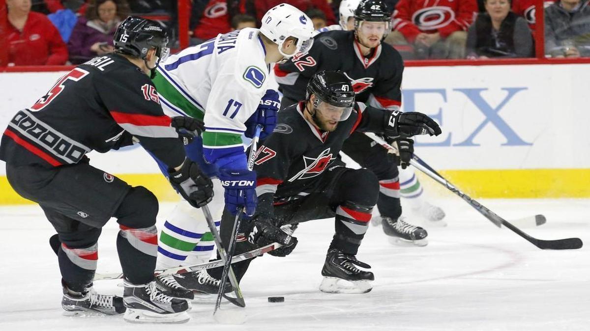 The Carolina Hurricanes' Andrej Nestrasil (15), Michal Jordan (47) and Joakim Nordstrom (42) defend the Vancouver Canucks' Radim Vrbata (17) during the second period at the PNC Arena in Raleigh.