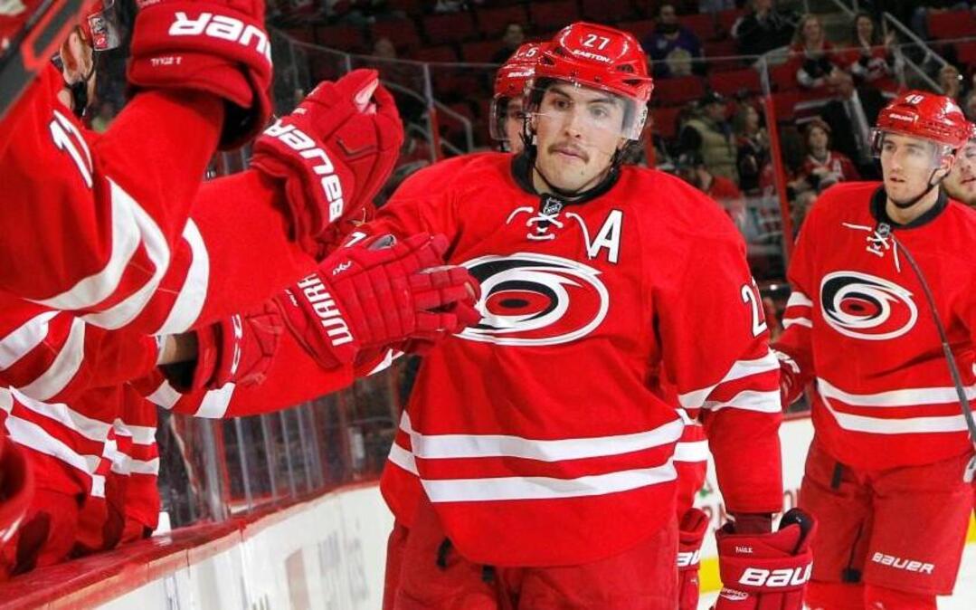 The Canes’ Justin Faulk (27) is congratulated by his teammates as he skates back to the bench after he scored during the second period of an NHL game played between the Carolina Hurricanes and the Los Angeles Kings at PNC Arena in Raleigh, N.C. on Nov. 22, 2015. The Canes beat the Kings 4-3.