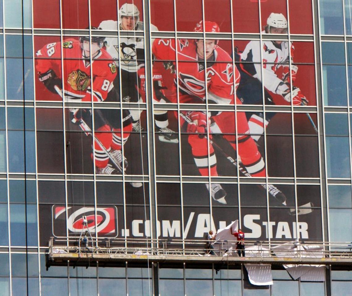 Workers install a huge decal on the RBC Plaza downtown advertising the NHL All-Star Game in Raleigh in Janurary 2011.
