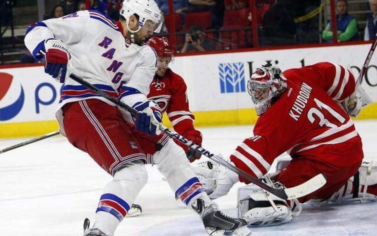 
The New York Rangers’ Rick Nash, left, battles with the Carolina Hurricanes’ Nathan Gerbe in front of goalie Anton Khudobin (31) during the first period of the Rangers’ Saturday night shootout victory in Raleigh.





