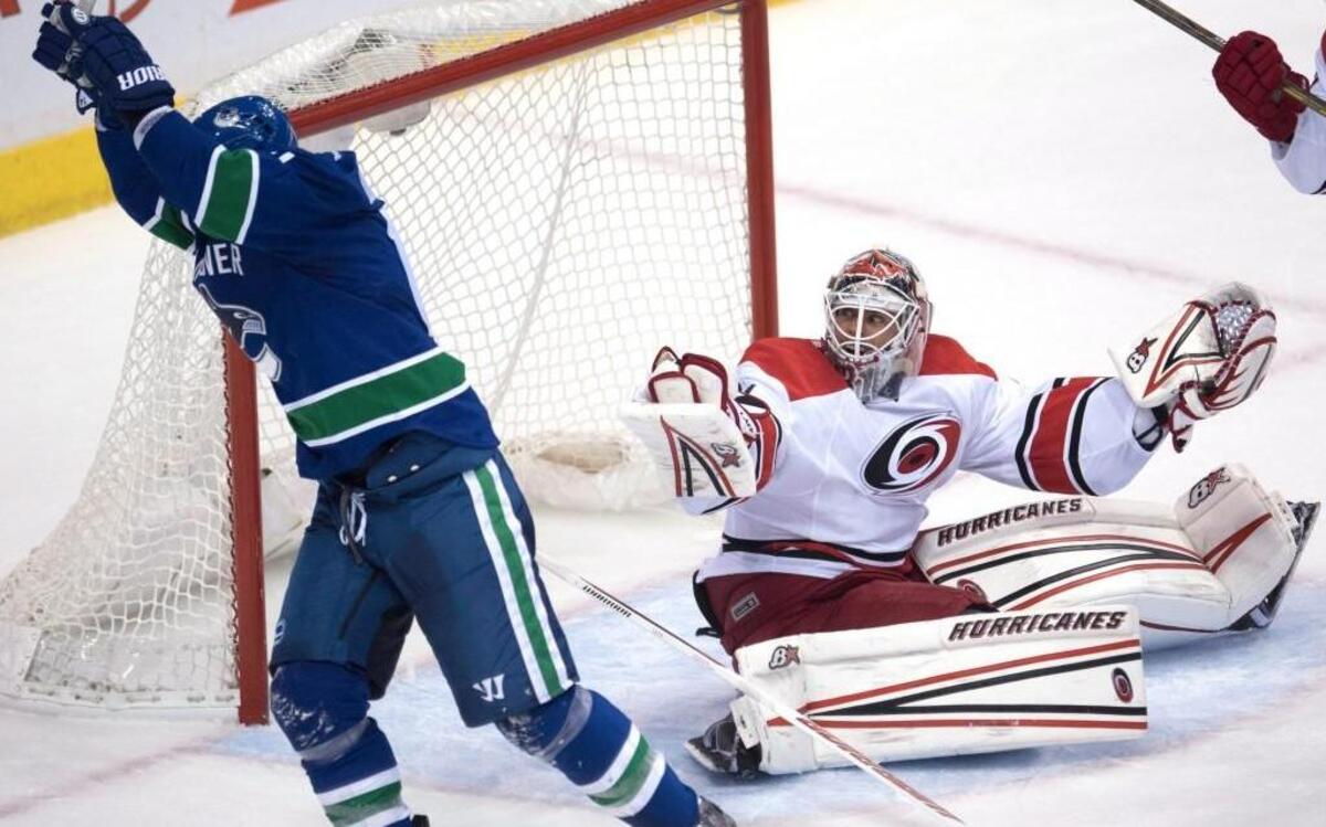 Carolina Hurricanes goalie Eddie Lack (31) reacts to a goal by Vancouver Canucks defenceman Ben Hutton (not pictured) as Vancouver Canucks right wing Alexandre Burrows (14) celebrates during third period NHL hockey action in Vancouver, British Columbia, Sunday, Oct. 16, 2016.