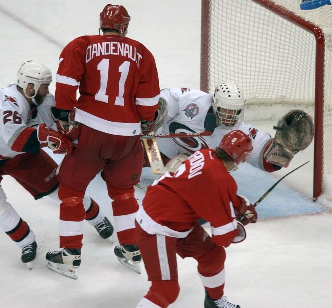 Detroit’s Igor Larionov, right, hits the game winner past Canes’ goalie Arturs Irbe in the 3rd OT period Saturday night June 8, 2002 (actually 1:16am on the morning of June 9th) to give the Red Wings a 3-2 win over Carolina and a 2-1 lead in the Stanley Cup finals. Looking on is Canes’ Erik Cole (26) and Wings’ Mathieu Dandenault (11).
