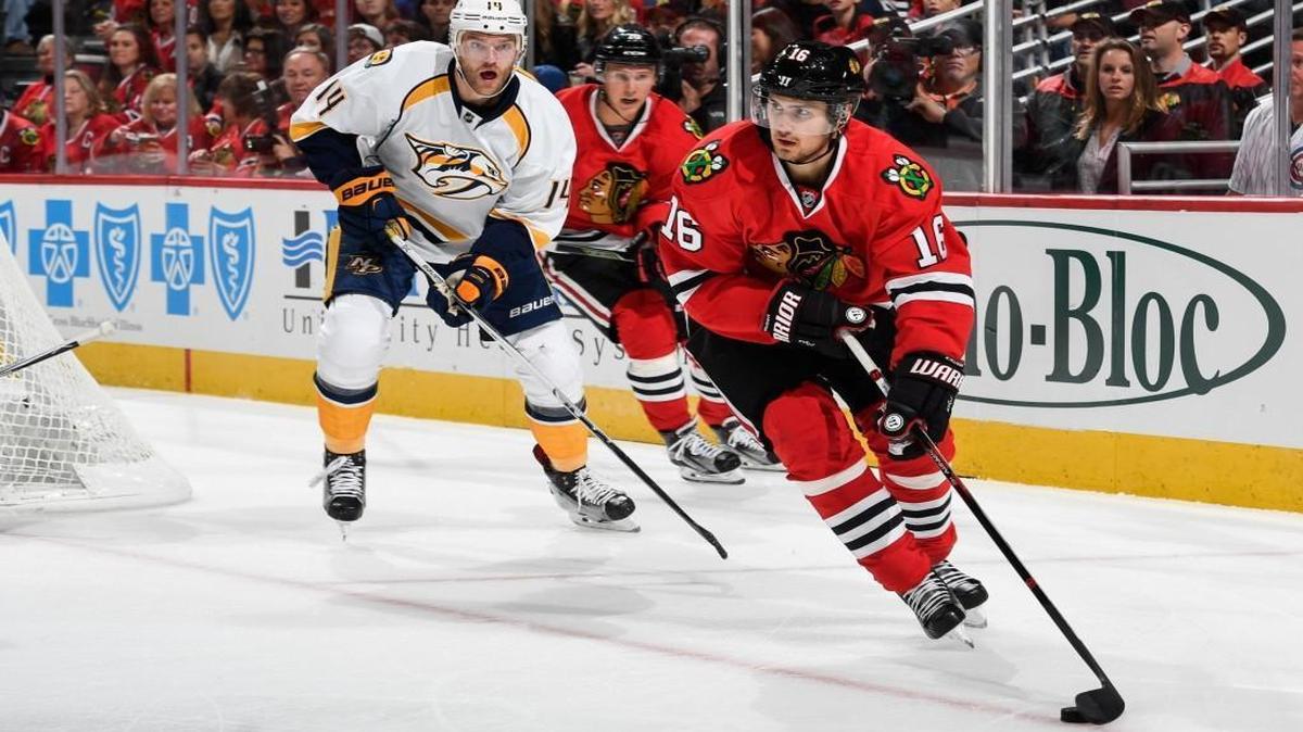 Marcus Kruger (16) of the Chicago Blackhawks grabs the puck ahead of Mattias Ekholm (14) of the Nashville Predators in the first period at the United Center on October 15, 2016 in Chicago.