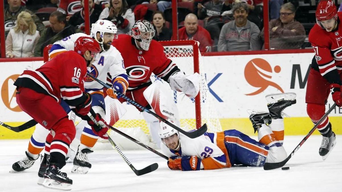 The Canes' Marcus Kruger (16), Cam Ward (30) and Trevor van Riemsdyk (57) defend the net against the Islanders' Andrew Ladd (16) and Brock Nelson (29) during the second period at PNC Arena on Nov. 19, 2017.