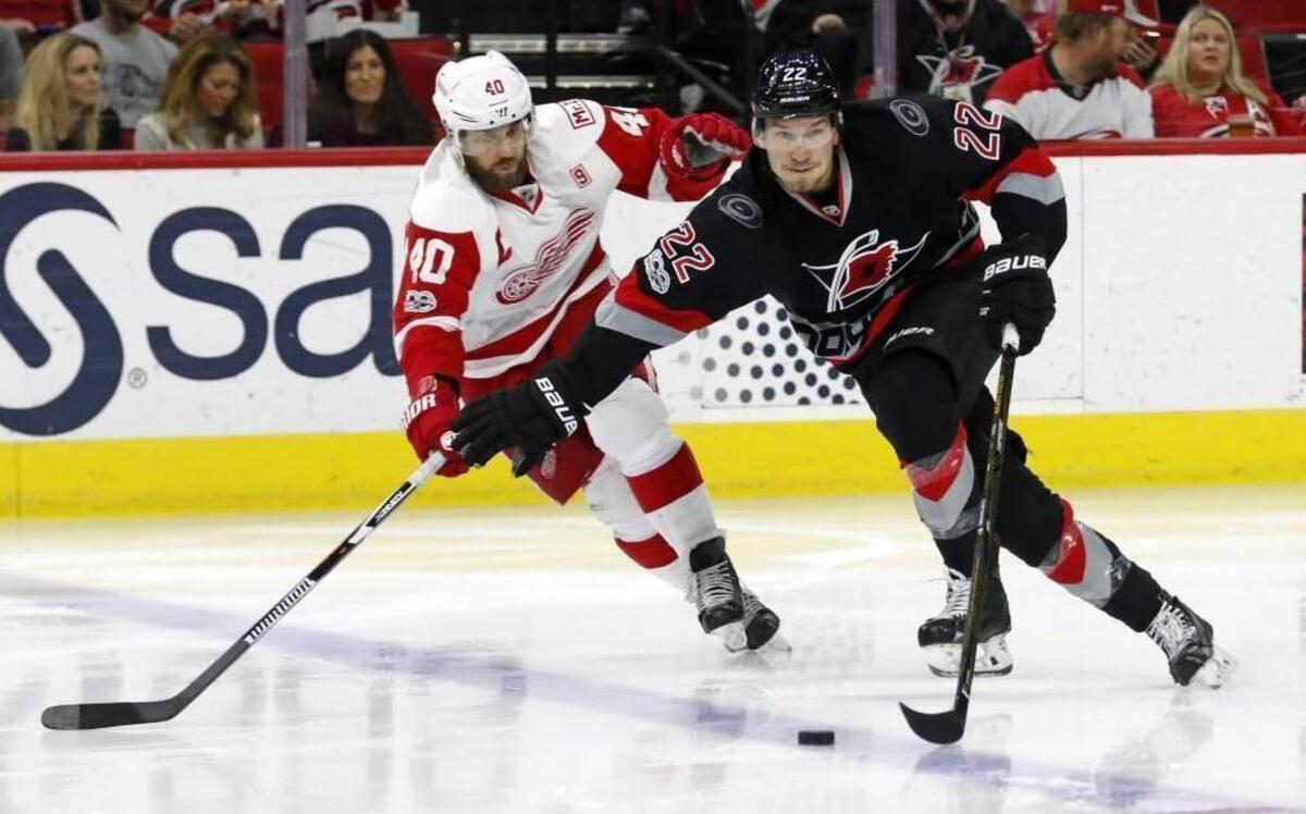 The Canes' Brett Pesce (22) moves the puck against the Detroit Red Wings' Henrik Zetterberg (40) during the second period at PNC Arena in Raleigh.