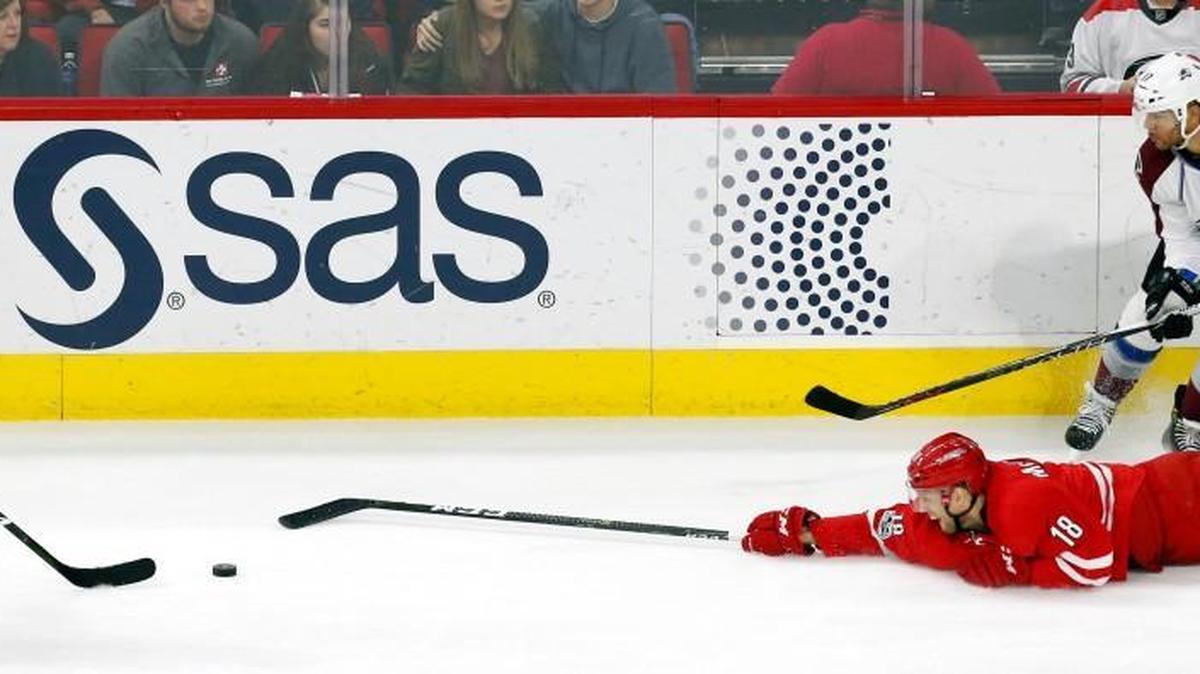 The Canes’ Jay McClement (18) dives for puck in front of Nathan MacKinnon (29) and Jarome Iginla (12) during game against Colorado Avalanche at PNC Arena on Feb. 17, 2017. The Avs beat the Canes 2-1 in OT.