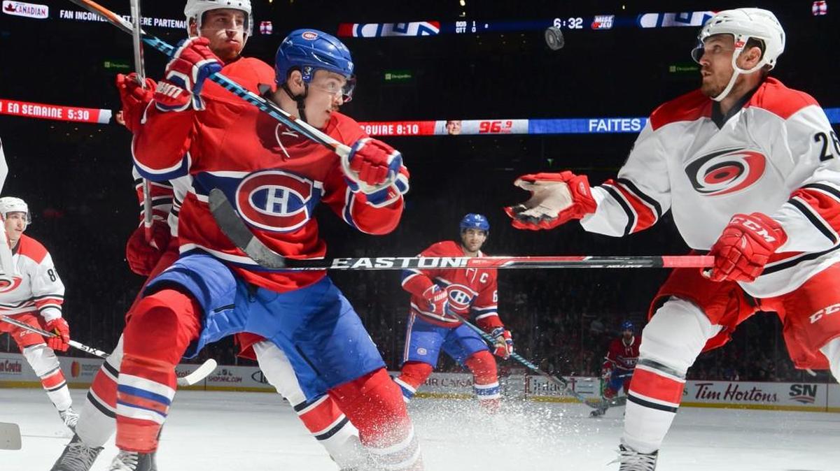 Brendan Gallagher #11 of the Montreal Canadiens and Matt Tennyson #26 of the Carolina Hurricanes fight for the puck in the NHL game at the Bell Centre on November 24, 2016 in Montreal, Quebec, Canada.