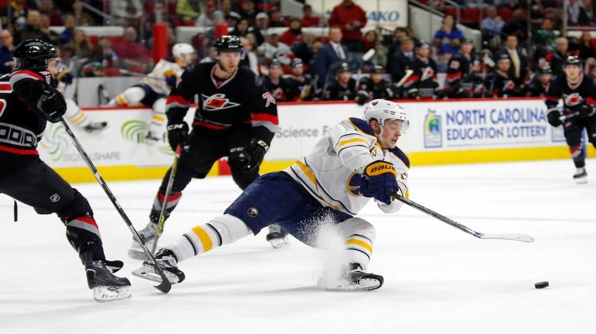 The Carolina Hurricanes' Ron Hainsey (65) and Jaccob Slavin (74) defend the Buffalo Sabres' Jack Eichel (15) during the second period of the Canes’ 3-2 loss at PNC Arena on March 22, 2016.